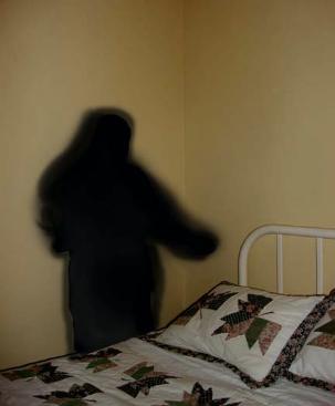 shadow figure standing by bed 